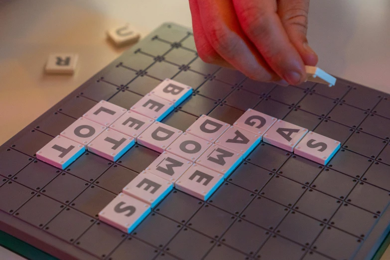 a close up of a person playing a game of scrabble, by Joe Bowler, interactive art, soft light 4 k in pink, square, slate, grey