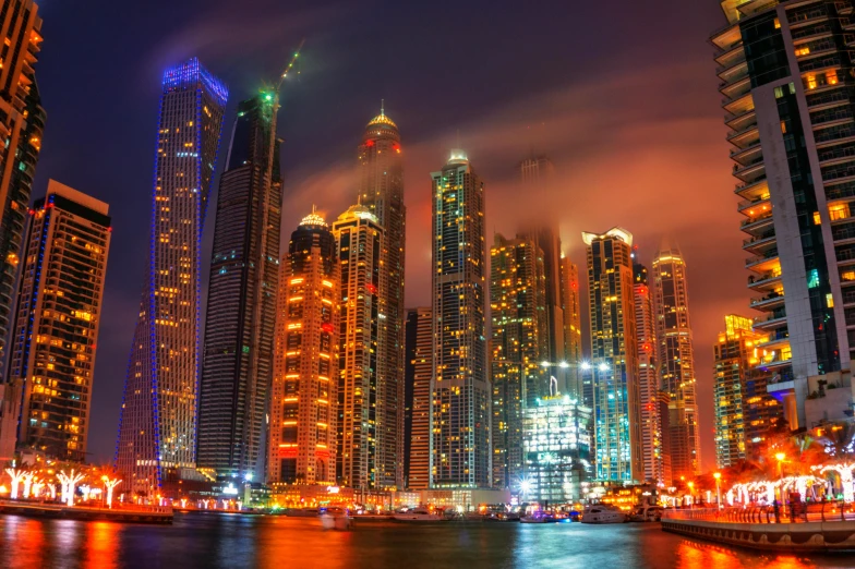 the city skyline is lit up at night, pexels contest winner, arabian nights, colorful projections, stacked image, high rises