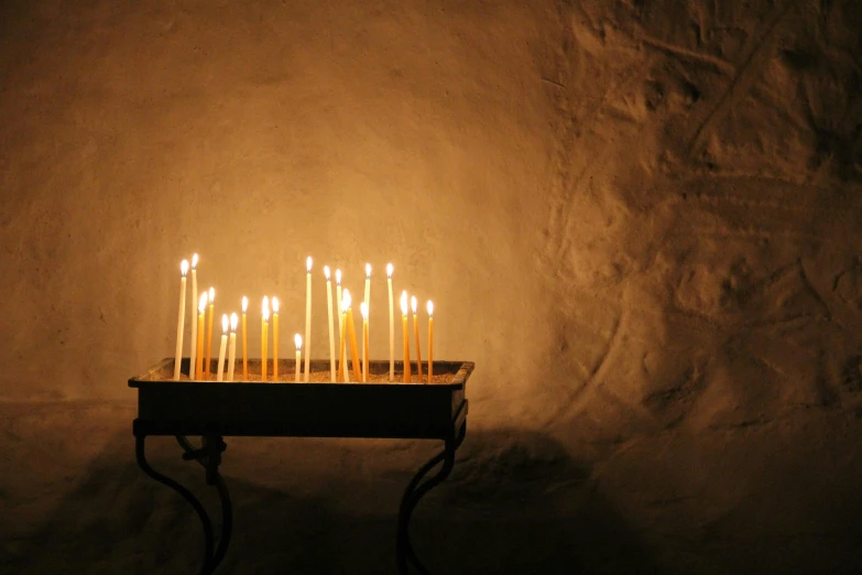 a bunch of candles sitting on top of a table, in an ancient vault, photograph