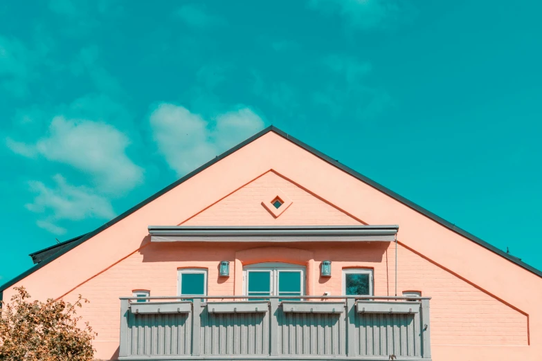 a pink building with a blue sky in the background, inspired by Wes Anderson, pexels contest winner, coloured in teal and orange, roof background, shot from roofline, pink and grey muted colors