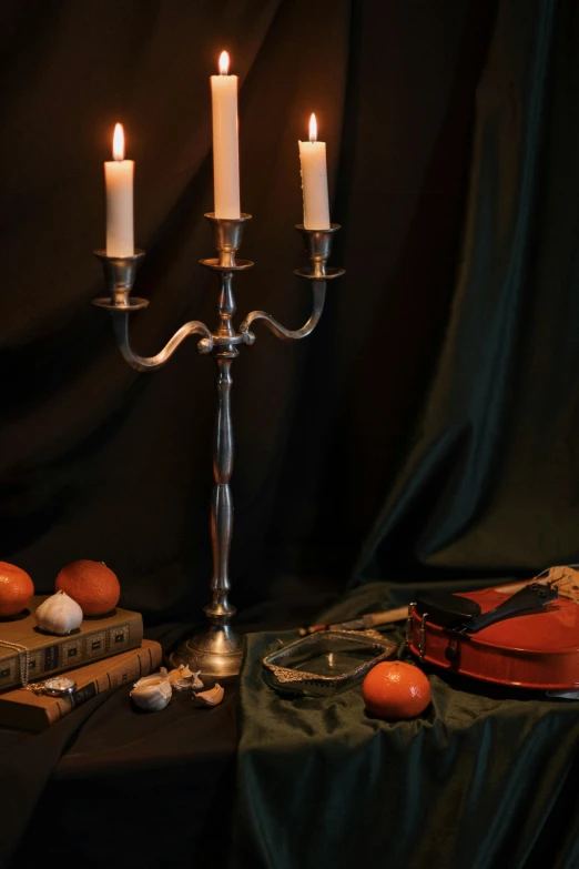 a couple of candles sitting on top of a table, a still life, inspired by Michelangelo Merisi da Caravaggio, baroque, pearl silverplate, concert, product display photograph, dark and dim