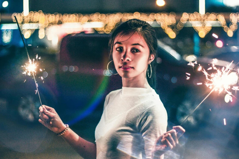a woman holding sparklers in her hands, by Adam Marczyński, a young asian woman, checking her phone, looking to the right, slightly pixelated