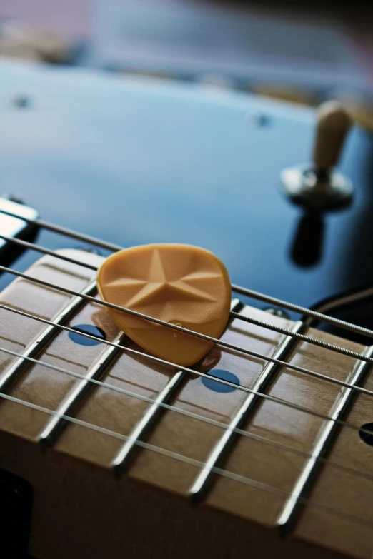 a close up of a guitar fret with a cookie on top of it, by Glennray Tutor, carved soap, smooth oval head, caramel, mini model