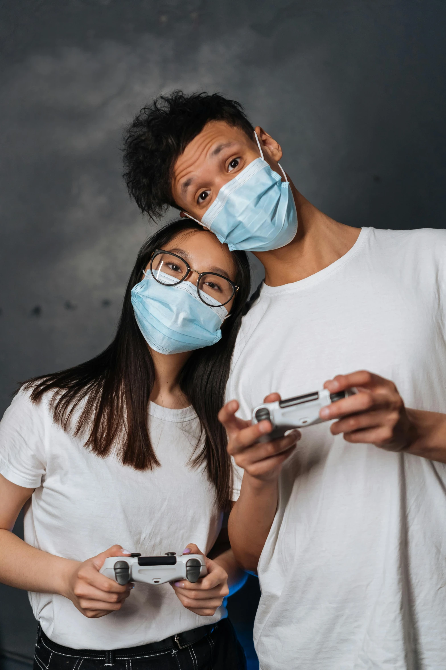 a man and woman wearing face masks while playing a video game, trending on pexels, hyperrealism, on a gray background, dentist, contracept, ismail inceoglu and ruan jia