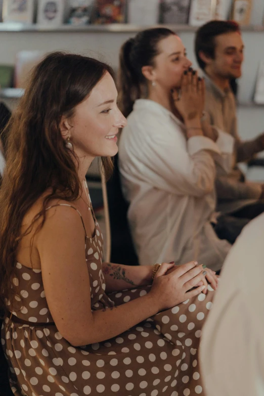 a group of people sitting around each other in a room, zoomed in, woman, enlightening, polka dot