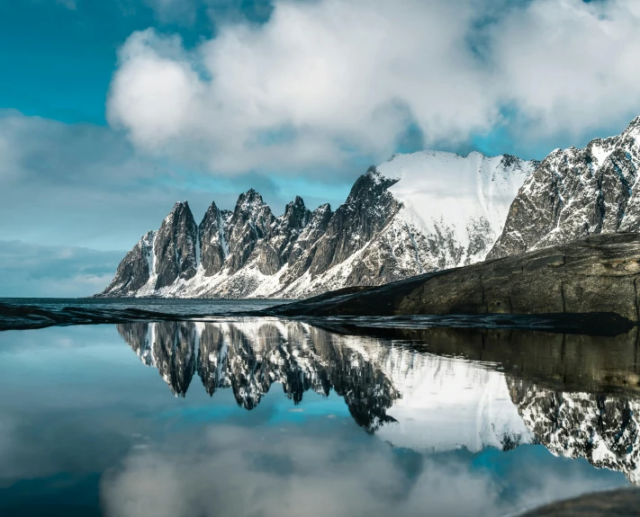 a body of water surrounded by snow covered mountains, by Harald Giersing, pexels contest winner, romanticism, tall stone spires, mirrored, arctic fish, high definition photo