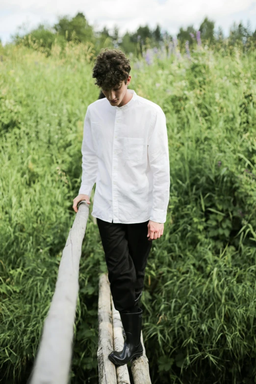 a man standing on top of a wooden bridge, an album cover, inspired by Jan Müller, unsplash, renaissance, wearing a white button up shirt, profile image, grazing, white poet shirt