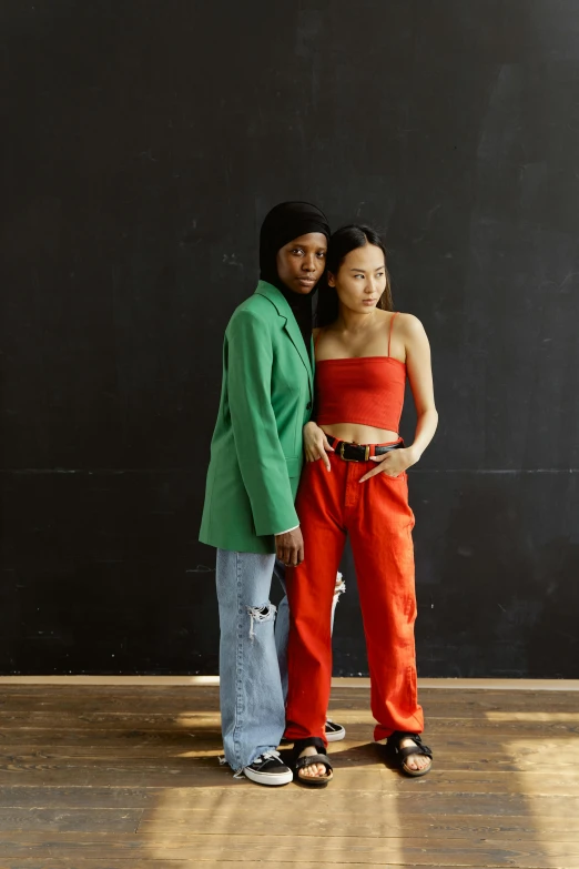 a couple of people standing next to each other, inspired by Wang Duo, trending on pexels, green bright red, young women, modeling studio, varying ethnicities