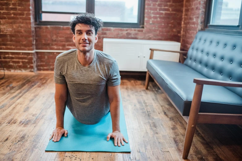 a man sitting on a yoga mat in a living room, promo image, background image, lachlan bailey, avatar image