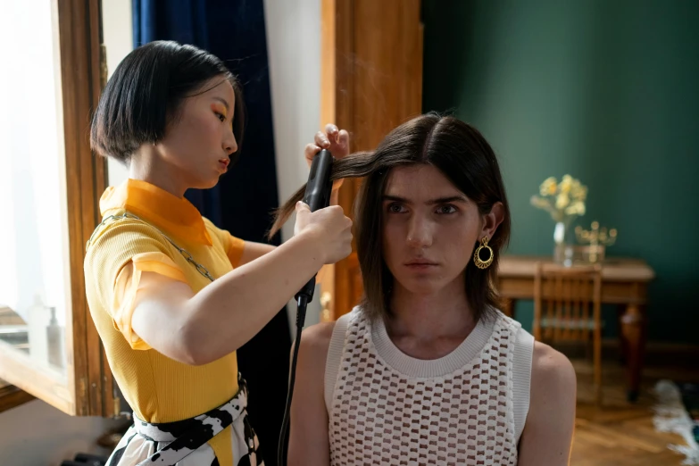 a woman cutting another woman's hair in a room, trending on pexels, hyperrealism, dua lipa, in the style wes anderson, looking straight to camera, promotional image