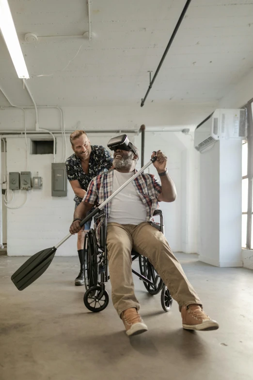 a man in a wheel chair holding a paddle, by Ben Zoeller, pexels contest winner, renaissance, two buddies sitting in a room, holding a giant flail, ( ( theatrical ) ), blind brown man