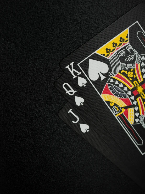 a couple of playing cards sitting on top of a table, thumbnail, black crown, uploaded, up close image