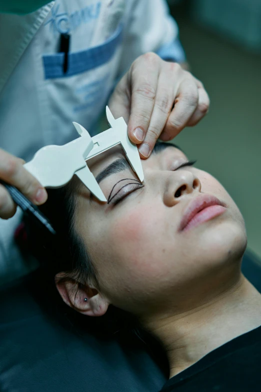 a woman getting her eye examined by a doctor, by Natasha Tan, hurufiyya, crisp contour lines, diecut, medium-shot, square