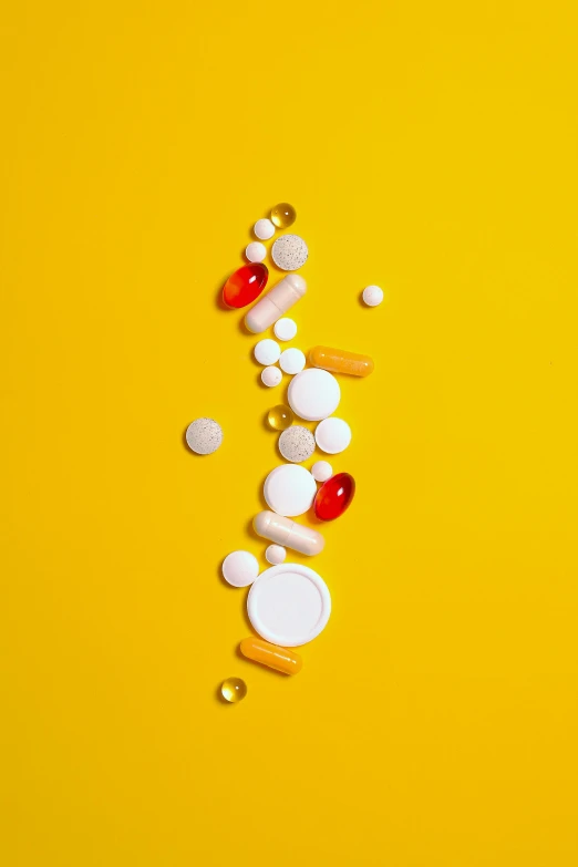 a bunch of pills on a yellow background, a picture, by Matt Cavotta, trending on pexels, altermodern, with a white background, a phoenix, detailed product shot, combine