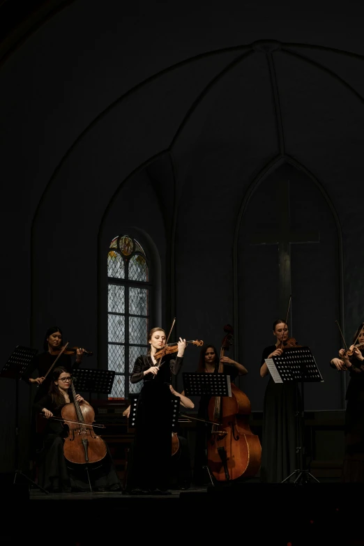 a group of people standing next to each other on a stage, an album cover, inspired by Anna Füssli, baroque, violin, scene set in a church, panoramic, photographed for reuters