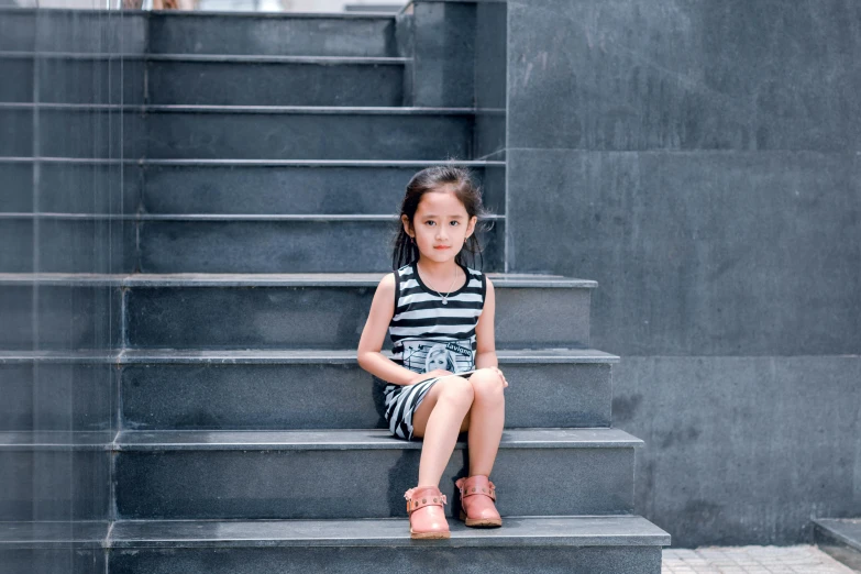 a little girl sitting on a set of stairs, pexels contest winner, asian female, striped, graphite, in a square