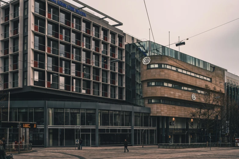 a large building sitting on the side of a road, inspired by Anton Möller, unsplash, brutalism, city square, chesterfield, brown, grey