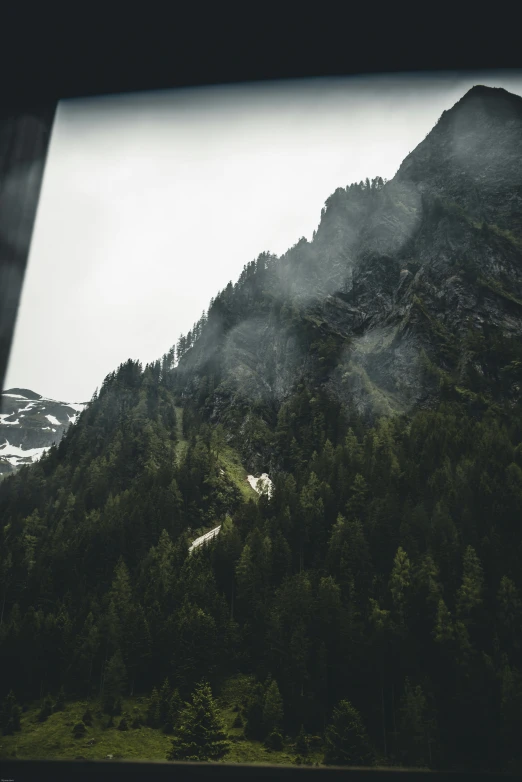 a view of a mountain from a train window, by Johannes Voss, unsplash contest winner, a massive cathedral in a forrest, helicopter view, rough and moody, solo hiking in mountains trees