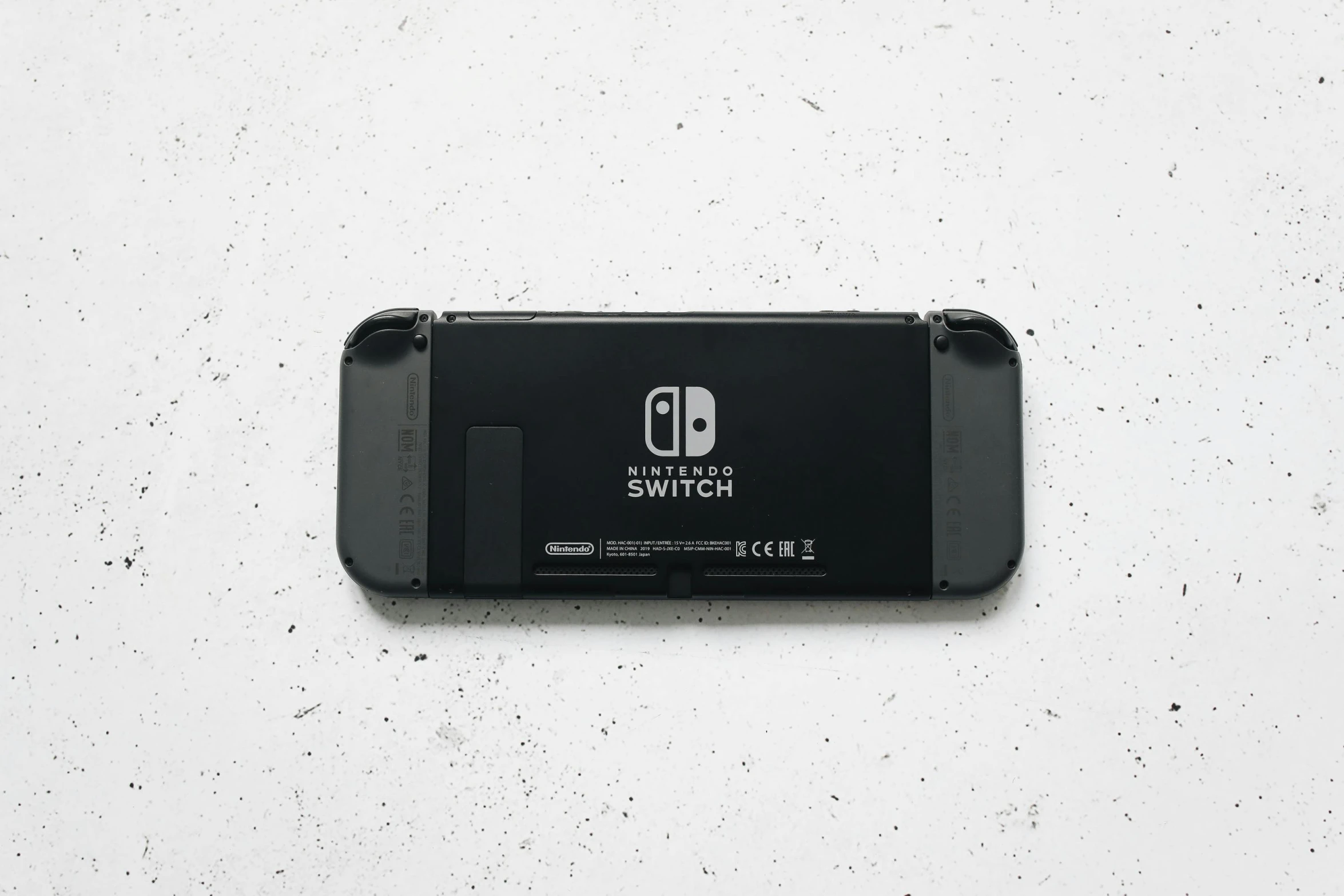 a close up of a nintendo switch lite, a picture, by Tom Wänerstrand, unsplash, minimalism, black color on white background, back view, on a gray background, made of plastic