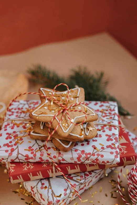 a pile of christmas presents sitting on top of a table, cookies, tiny stars, orange ribbons, ginger