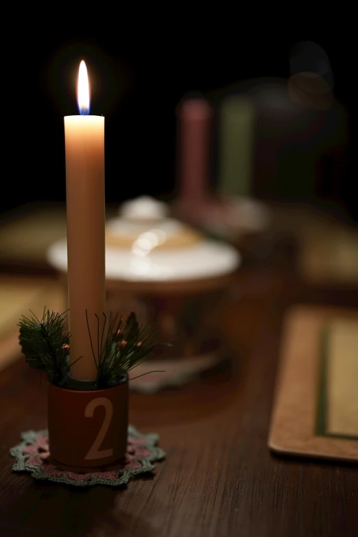 a lit candle sitting on top of a wooden table, festive, pestle, back towards camera, ready to eat