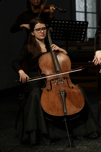 a group of people playing musical instruments in a room, antipodeans, cello, promo image, portrait of sanna marin, performing on stage