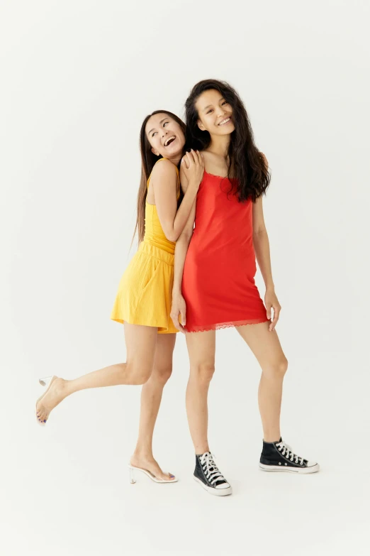 a couple of women standing next to each other, short minidress, yellow and red, gen z, kids