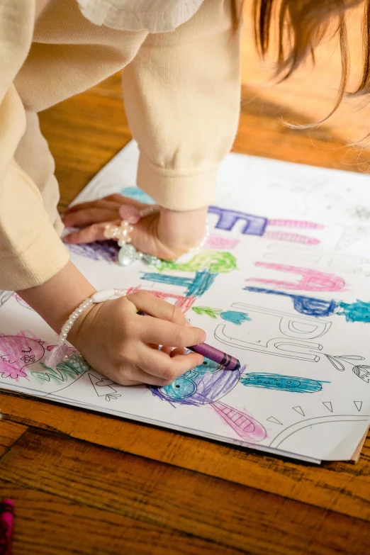 a little girl is drawing on a piece of paper, by Winona Nelson, crayon art, coloring book outline, detail shot, promo image, on high-quality paper