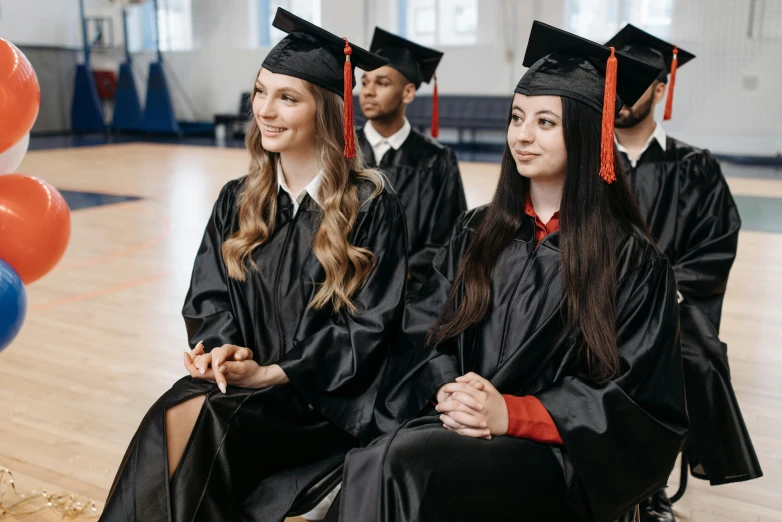 a group of people sitting on top of a wooden floor, a portrait, shutterstock, academic art, wearing an academic gown, 🤬 🤮 💕 🎀, 2263539546], decorations