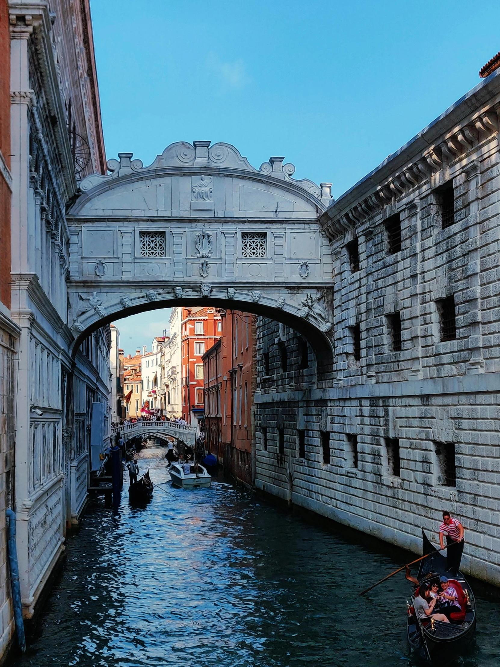 a gondola going under a bridge on a canal, a photo, by Canaletto, pexels contest winner, renaissance, profile image, massive arch, payne's grey and venetian red, square