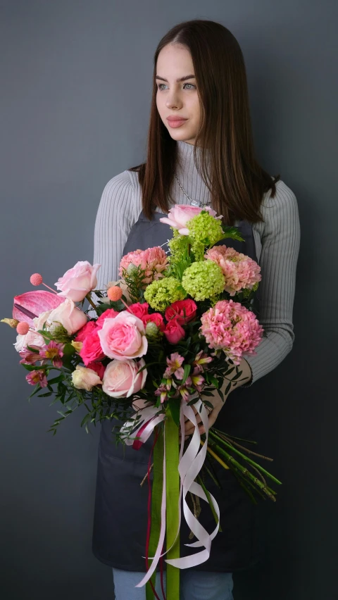 a woman holding a large bouquet of flowers, pink and pink details, on grey background, vibrant colour, comforting