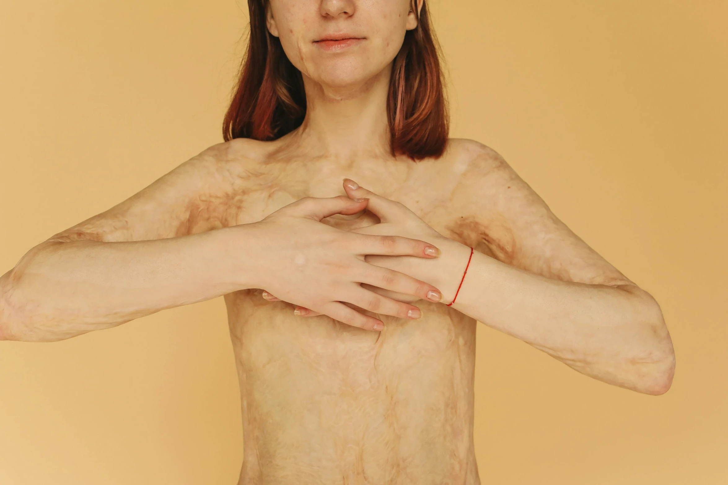 a woman standing with her hands on her chest, an album cover, inspired by Elsa Bleda, trending on pexels, hyperrealism, human-skin pelt, emaciated, her skin is light brown, full body 8k