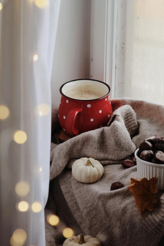 a cup of coffee sitting on top of a window sill, a still life, inspired by Elsa Bleda, trending on pexels, 🍂 cute, polkadots, red velvet, multiple lights