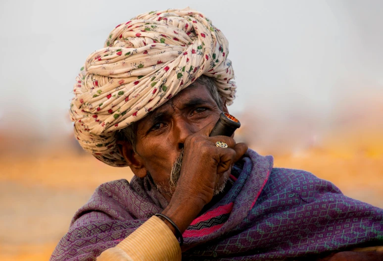 a man in a turban smoking a cigarette, pexels contest winner, tribals, people watching around, portrait image, dusty air