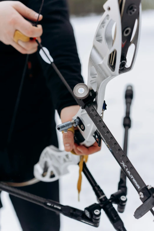 a close up of a person holding a bow in the snow, white mechanical details, measurements, hooked - up, nordic