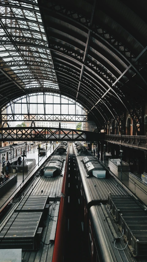two trains parked next to each other in a train station, inspired by Thomas Struth, unsplash contest winner, art nouveau, roofs, square, spanish, high quality photo