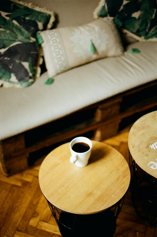 a coffee cup sitting on top of a wooden table, couch, sustainable materials, bongos, no duplicate image