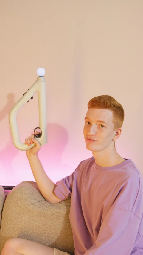 a man sitting on a couch holding a video game controller, an album cover, by Thomas Furlong, very long neck, 3d printed, albino, gen z