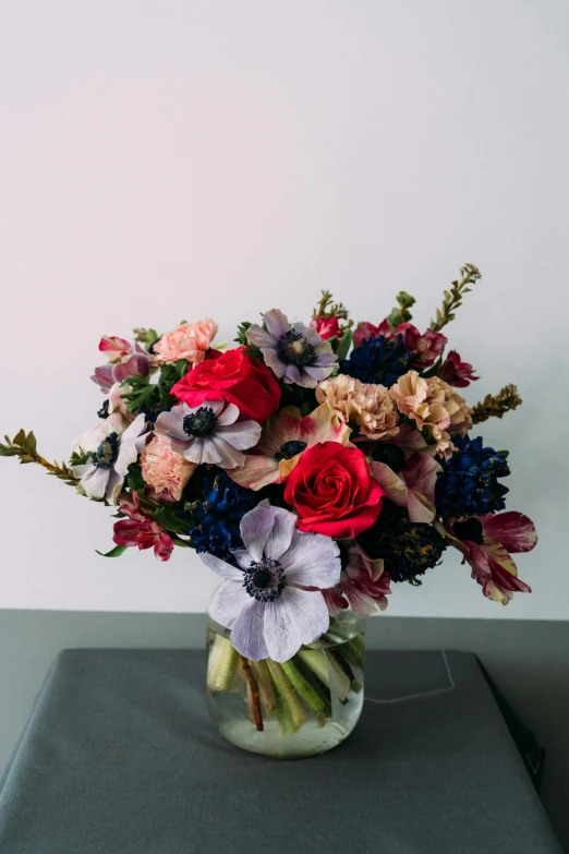 a vase filled with flowers on top of a table, inspired by François Boquet, romanticism, muted blue and red tones, anemone, lush and colorful eclipse, more and more flowers
