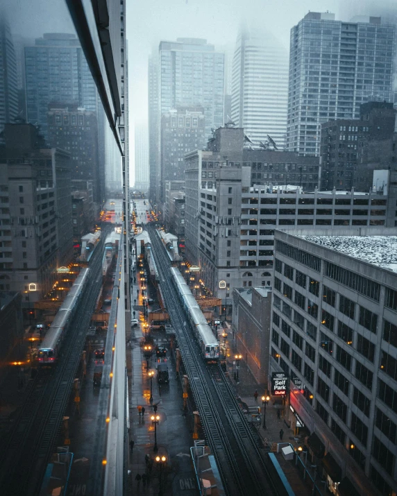 a train traveling through a city next to tall buildings, by Adam Rex, pexels contest winner, dreary lighting, non-binary, toronto city, overview