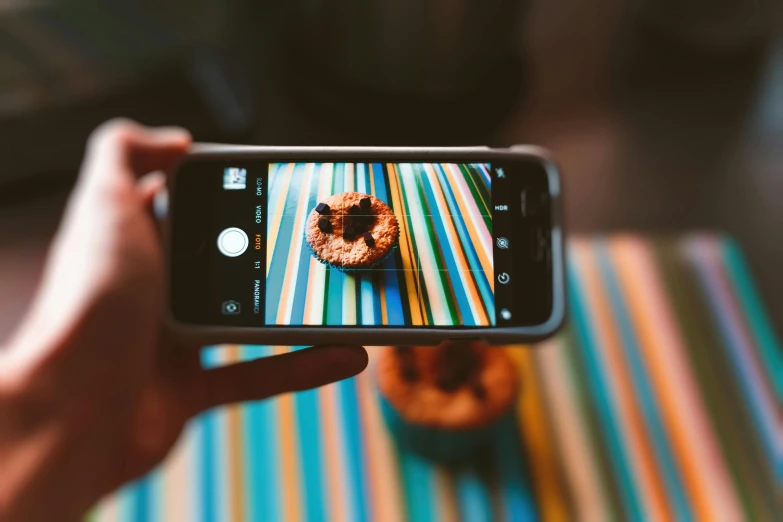 a person taking a picture of a donut, a picture, trending on pexels, fan favorite, spying discretly, iphone video, a wooden