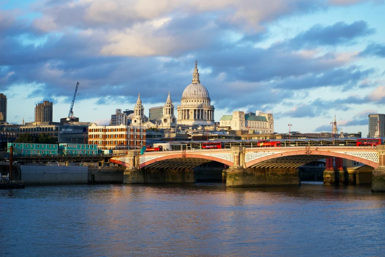 a bridge over a body of water with a city in the background, by Christopher Wren, travel guide, building along a river, multicoloured, petite