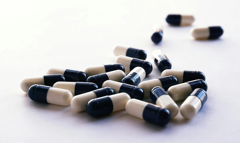 a bunch of pills sitting on top of a table, antipodeans, ivory and ebony, ultramarine, with a white background, lined up horizontally