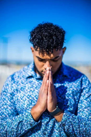 a man in a blue shirt is praying, trending on unsplash, ashteroth, slide show, multiple stories, multicoloured