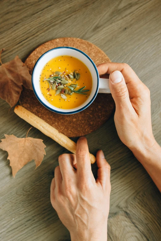 a person holding a spoon over a bowl of soup, pexels contest winner, renaissance, autumnal colours, square, food commercial 4 k, a wooden