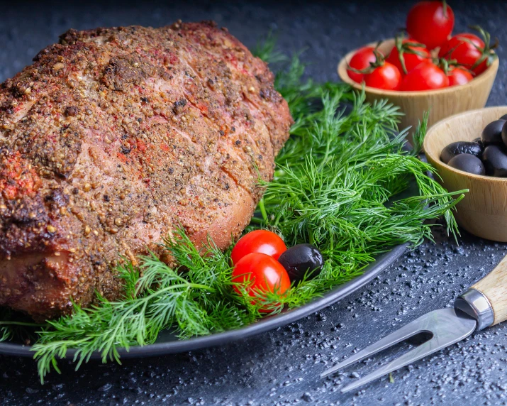 a meatloaf sitting on top of a plate next to a bowl of olives and tomatoes, by Julia Pishtar, pexels contest winner, giant pig grass, volcanic, festive, ukrainian