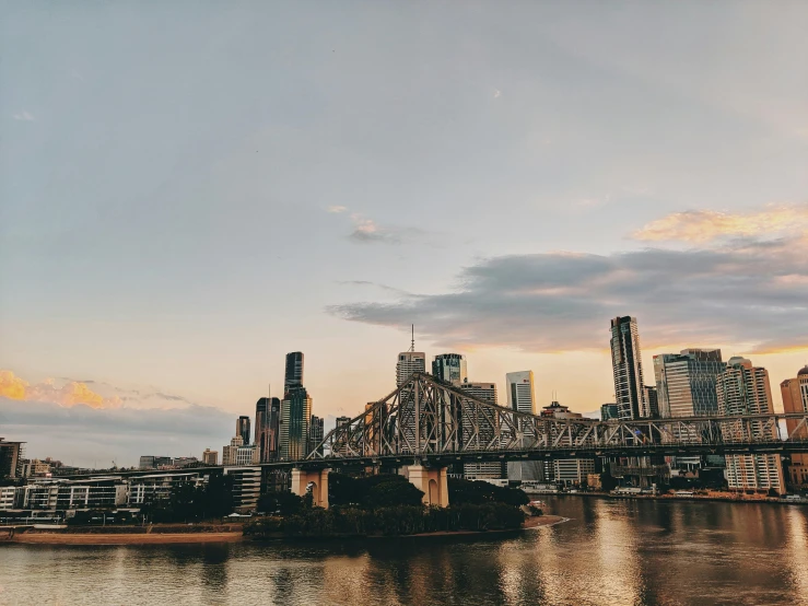 a bridge over a body of water with a city in the background, pexels contest winner, happening, lachlan bailey, late afternoon, vsco, skyline showing