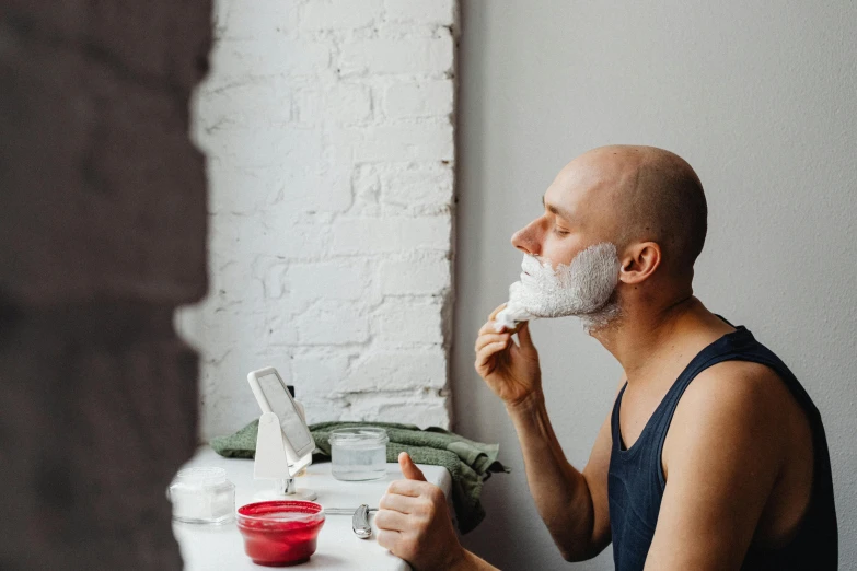a man shaving his face in front of a window, trending on pexels, hyperrealism, middle aged balding superhero, square masculine jaw, avatar image