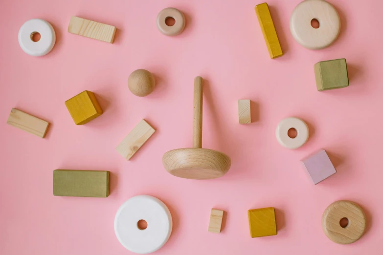 a bunch of wooden toys on a pink surface, inspired by Frederick Hammersley, pexels contest winner, mortar, a round minimalist behind, woodland, high-quality wallpaper