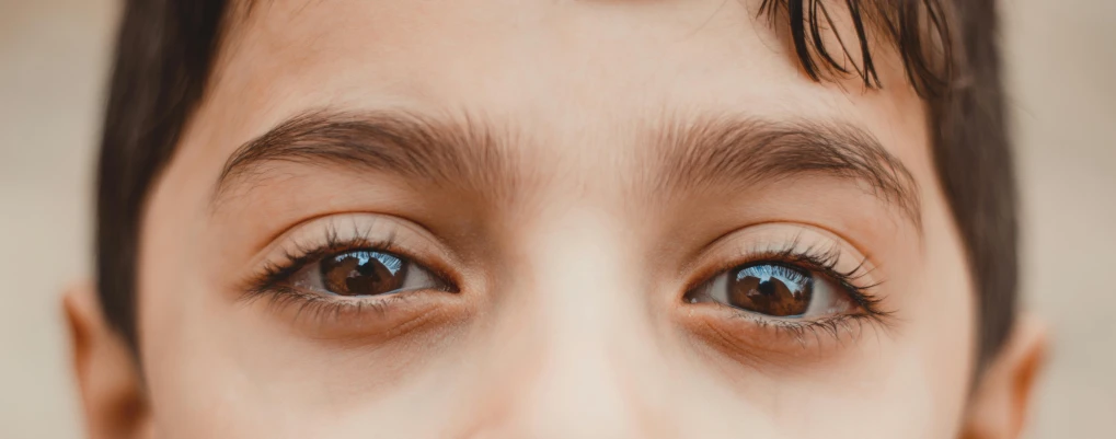 a close up of a young boy brushing his teeth, trending on pexels, hyperrealism, close - up shot of eyes, third eye in middle of forehead, brown hair and large eyes, eyes in different directions